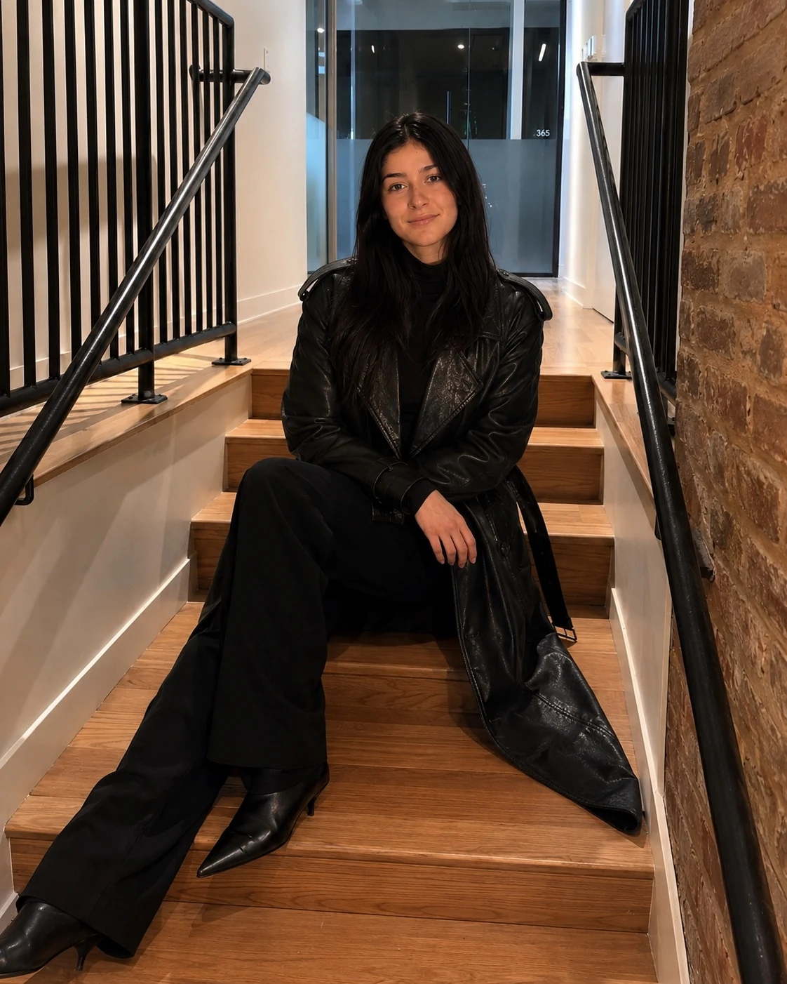 Model seated on stairs in black leather