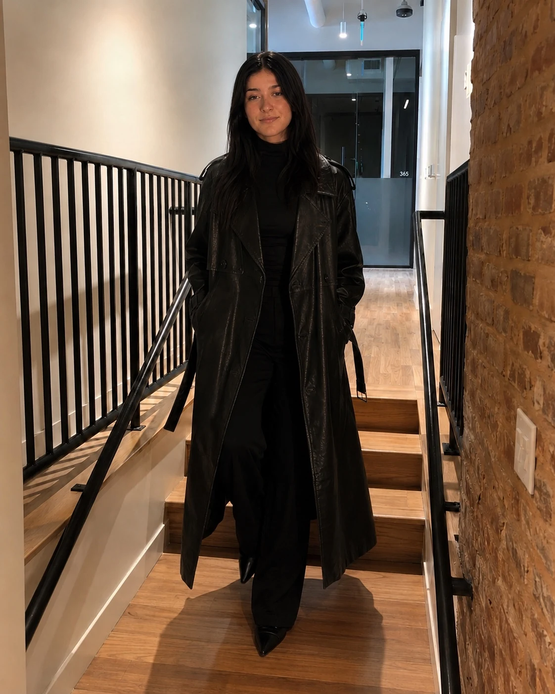 Model walking in a long black leather coat